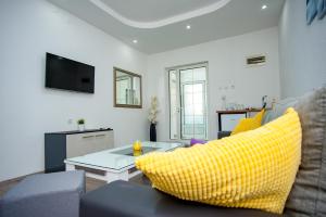 ein Wohnzimmer mit einem gelben Sofa und einem Tisch in der Unterkunft Villa Beautiful in Gevgelija