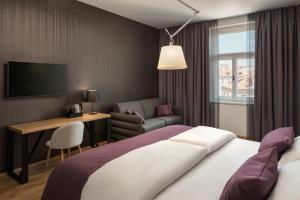 a hotel room with a bed and a desk and a television at MOODs Charles Bridge in Prague