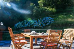 a wooden table and chairs with blue flowers at Valle dei Mulini - Lake Como in Bellano