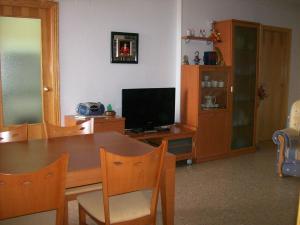a dining room with a table and a television at Apart. BREZO Nova-Canet. Playa in Canet de Berenguer
