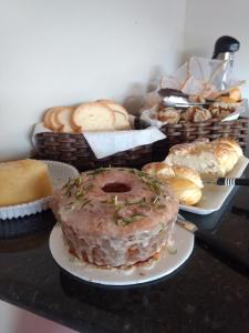 uma mesa com diferentes tipos de pão e pastelaria em Pousada Recanto do Lago 1 em Capitólio