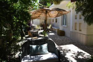 un patio con sombrilla y una silla con almohada en B&B Al Vecchio Glicine, en Torre Canne