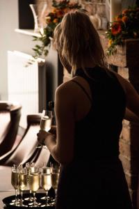 a woman standing in front of a tray of wine glasses at Friars Wynd Hotel in Stirling