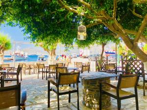 a group of tables and chairs under a tree at Patras Rooms est 1990 in Fournoi