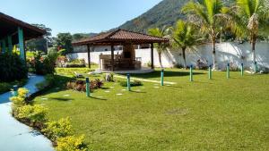 a garden with a gazebo in the grass at Mata Atlântica Chalés - Praia da Lagoinha, Ubatuba - SP in Ubatuba