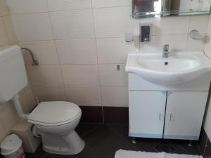 a bathroom with a white toilet and a sink at Villa Espero in Trogir