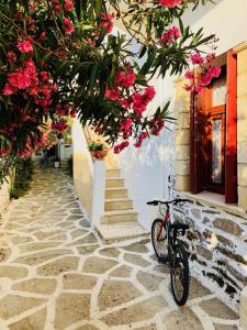 ein Fahrrad neben einem Gebäude mit Blumen geparkt in der Unterkunft Patras Rooms est 1990 in Fourni Ikaria