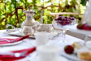 A Touch of English B&B في كيلونا: طاولة مع غلاية الشاي وأطباق الطعام