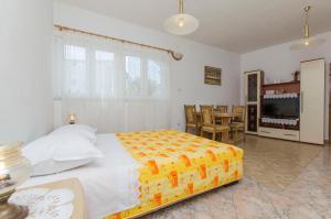 a bedroom with a large bed and a dining room at Apartment Rosa in Primošten