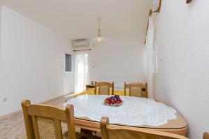 a dining room table with a bowl of fruit on it at Apartment Rosa in Primošten