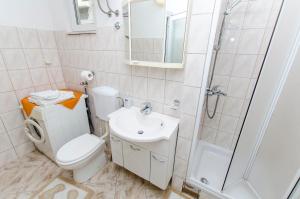 a bathroom with a toilet and a sink and a shower at Apartment Rosa in Primošten +18 photos