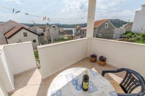 a white balcony with a table and a bottle of wine at Apartment Rosa in Primošten