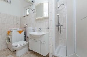 a bathroom with a toilet and a shower and a sink at Apartment Rosa in Primošten +18 photos