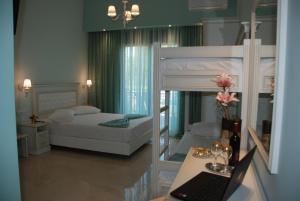 a bedroom with a bunk bed with a laptop on a desk at Elxis Luxury Resort in Nea Vrasna