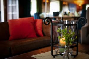 a glass vase with a candle on a table with a couch at Lifjellstua in Lifjell