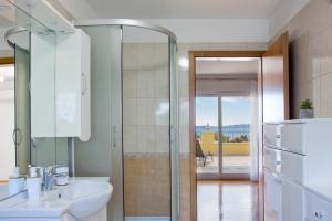 a bathroom with a sink and a glass shower door at Apartment Noel in Kaštela +40 photos