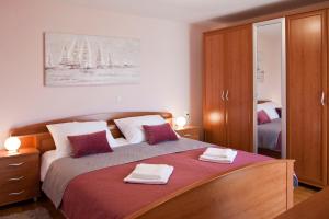 a bedroom with a large bed with two towels on it at Apartment Noel in Kaštela