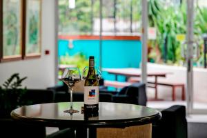 a bottle of wine sitting on a table with a glass at The Wellington Apartment Hotel in Brisbane