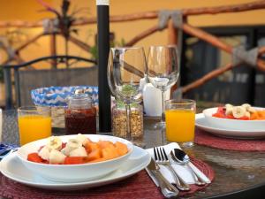 a table with plates of food and glasses of orange juice at Hotel Real Colonial in Valladolid