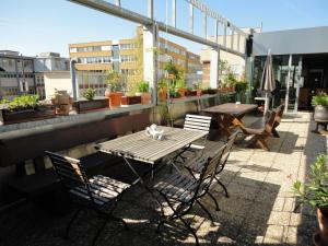 d'une table et de chaises sur un balcon orné de plantes. dans l'établissement B & B Auf dem Wolf, St. Jakob, à Bâle