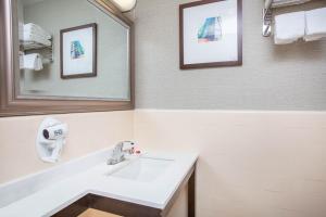 a bathroom with a sink, mirror, and toilet at Baymont by Wyndham San Diego Downtown in San Diego