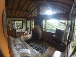 a view of a living room with a tv and a couch at Chales Bamboo Jungle in Petrópolis