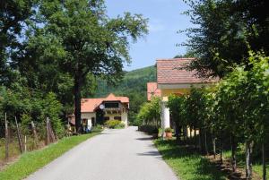 a road in a village with houses and trees at Weingut Schlafgut Genussgut Lorenz in Kitzeck im Sausal