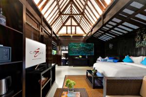 1 dormitorio con 1 cama y TV en una habitación en Canvas Escape Resort, en Ubud
