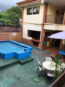 a pool in the backyard of a house with a table and chairs at Cabinas Yolymar in Puntarenas