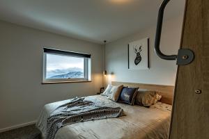 a bedroom with a bed and a window at Le Chalets- King of the mountain- sleeps 18 by ABM in Falls Creek