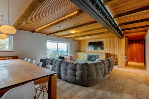 a living room with a large couch and a table at Le Chalets- King of the mountain- sleeps 18 by ABM in Falls Creek