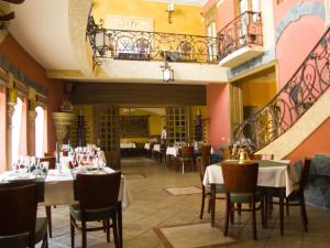 a restaurant with tables and chairs and a balcony at Letuchiy Gollandets in Uzhhorod