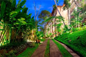 a walkway through a garden in front of a building at The Lokha Ubud Resort, Villas & SPA in Ubud