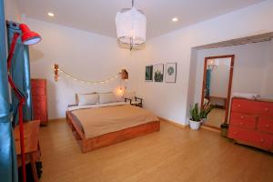 a bedroom with a bed and a dresser and a mirror at Six Six Garden in Da Lat