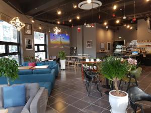 a restaurant with blue couches and tables and plants at Maison de Geoje in Geoje 