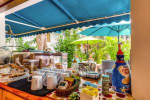a table with cups and plates and an umbrella at Key West Harbor Inn - Adults Only in Key West