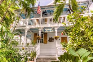 基韋斯特的住宿－Key West Harbor Inn - Adults Only，一座白色的房子,上面有美国国旗