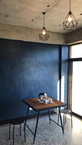 a wooden table in a room with a blue wall at Gather in Tainan