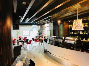 un restaurante con un bar con mesas y sillas rojas en Discovery Motel - Zhonghe, en Zhonghe