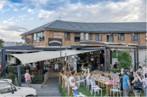 eine Gruppe von Personen, die außerhalb eines Gebäudes stehen in der Unterkunft Figtree Hotel Wollongong in Wollongong