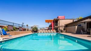 - une piscine d'eau bleue dans un bâtiment dans l'établissement Best Western Desert Villa Inn, à Barstow