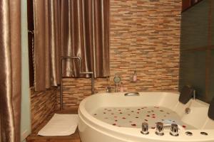 a bathroom with a bath tub with flowers on the floor at Skinetics Wellness Center Boutique Hotel in Iloilo City