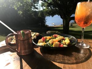 a table with a plate of food and a drink at The Long View Lodge in Long Lake