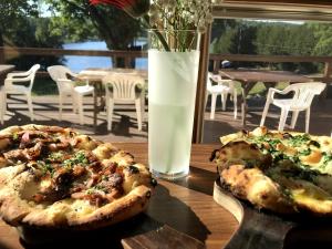 two pizzas sitting on a table with a glass of milk at The Long View Lodge in Long Lake