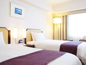 Postel nebo postele na pokoji v ubytování Hotel New Otani Takaoka
