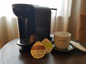 una cafetera y una taza de café sobre una mesa en Hotel New Otani Takaoka en Takaoka