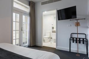紐卡索的住宿－幸運酒店，一间卧室配有一张床,墙上配有电视