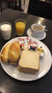 a white plate with a sandwich and bread on a table at Royal Hotel in Brussels