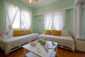 Zimmer mit 2 Betten, gelben Kissen und einem Tisch in der Unterkunft Kosta's Cottage House in Athen