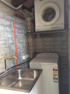 a small kitchen with a sink and a washing machine at Alpha Centauri Townhouses in Jindabyne